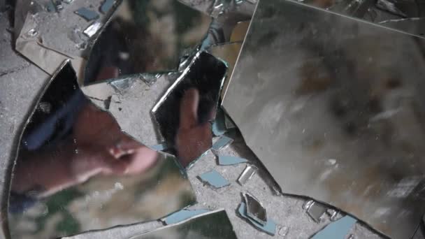 Hombre deprimido y enojado mira en fragmentos de vidrio y se extiende por ella — Vídeo de stock
