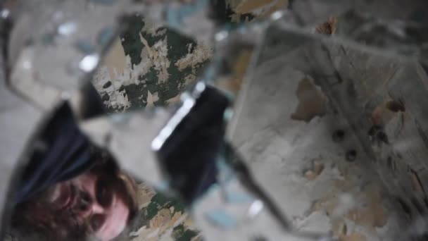 Депрессивный и злой человек смотрит в осколки разбитого стекла — стоковое видео
