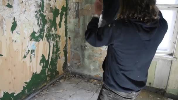 Depressziós és dühös ember dob egy tükröt a sarokba egy elhagyott házban — Stock videók
