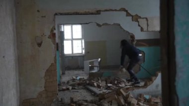 Depresyonda ve deli bir adam eski bir terk edilmiş evde taş atar