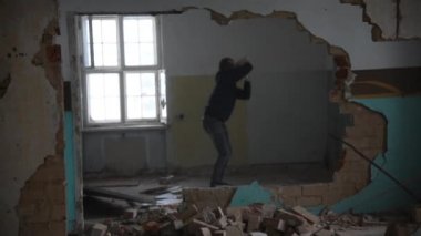Depresyonda ve deli bir adam eski bir terk edilmiş evde taş atar