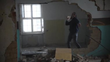 Depresyonda ve deli bir adam eski terk edilmiş bir evde bir duvara isabet