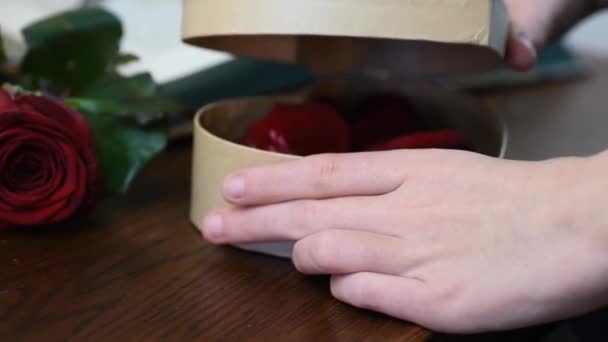 Valentinstagsgeschenk. junges Mädchen öffnet Herz Geschenkbox mit Rosenblättern — Stockvideo