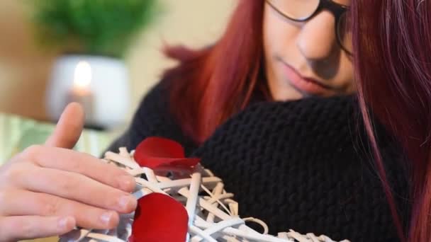 Regalo di San Valentino. Giovane ragazza con cuore in legno bianco con petali di rosa — Video Stock