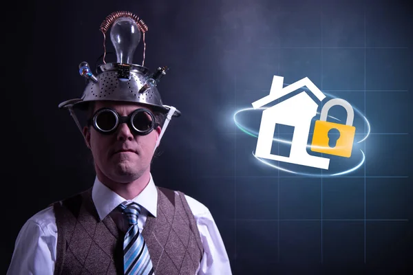 Funny nerd or geek with aluminium hat looking to camera with home insurance icon having an idea