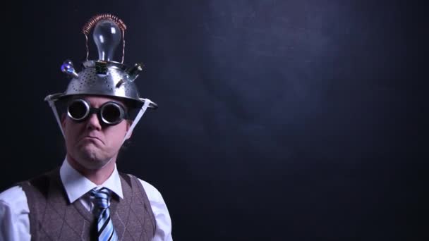 Нерд з алюмінієвим капелюхом дивиться в камеру — стокове відео