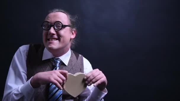 Nerd amoroso con un corazón como regalo — Vídeo de stock