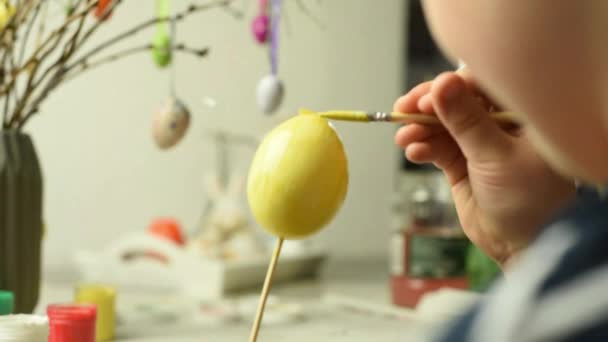 Niño pequeño pintando huevos de Pascua — Vídeo de stock