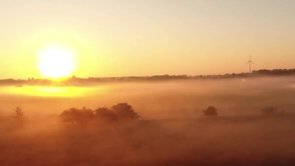 Vuelo sobre campos de niebla con amanecer y turbinas eólicas — Vídeos de Stock