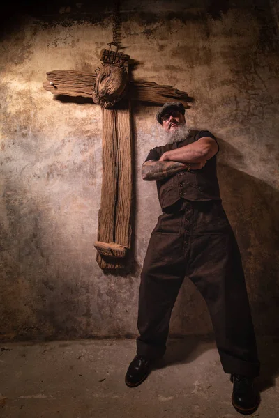 Retrato de hipster barbudo con tatuajes en sus brazos y cruz de Jesús — Foto de Stock