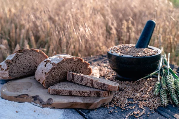 Brotmehl und Mais auf einem alten Tisch mit Maisfeld im Hintergrund — Stockfoto