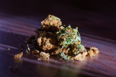 Ahşap arka plan üzerinde tıbbi marihuana tomurcukları yakın