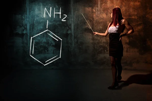 Σέξι κορίτσι ή γραμματέας ή μαθήτρια παρουσιάζοντας χημική φόρμουλα ανιλίνης — Φωτογραφία Αρχείου