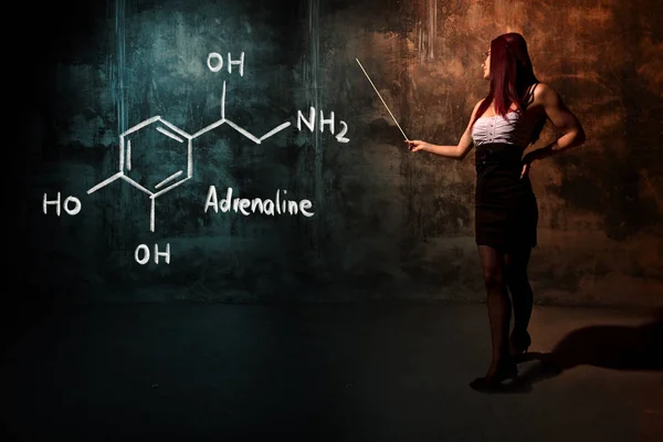 Sexy chica o secretaria o estudiante que presenta fórmula química dibujada a mano de adrenalina — Foto de Stock