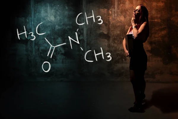 Sexy chica o secretaria o estudiante que presenta la fórmula química dibujada a mano de la dimetilacetamida — Foto de Stock