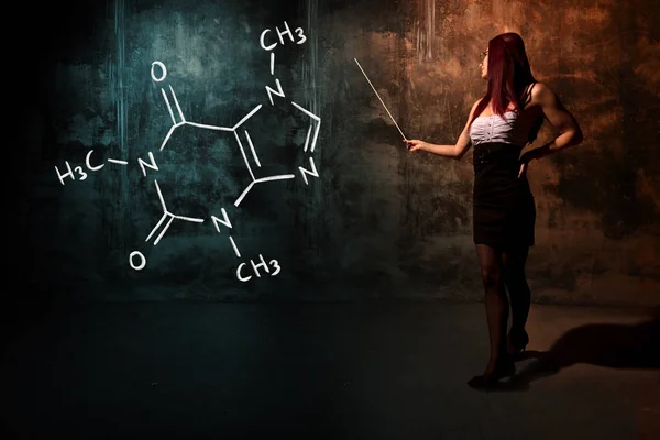 Сексуальна дівчина або секретарка або студентка, що представляє намальовану хімічну формулу кофеїну — стокове фото