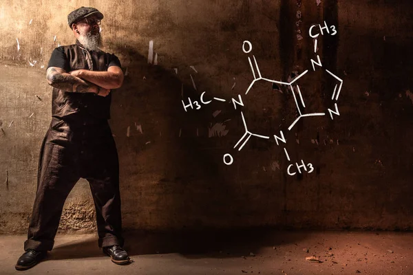 Viejo barbudo presentando fórmula química dibujada a mano de cafeína — Foto de Stock