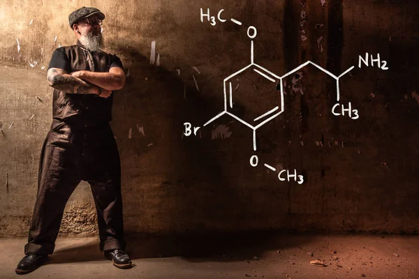 Bärtiger alter Mann präsentiert handgezeichnete chemische Formel von Dimethoxybromoamphetamin dob — Stockfoto