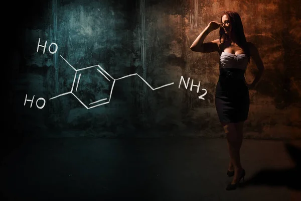 Сексуальна дівчина або секретарка або студентка, що представляє намальовану хімічну формулу дофаміну — стокове фото