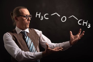 Diethylether'in elle çizilmiş kimyasal formüllerini sunan Profesör