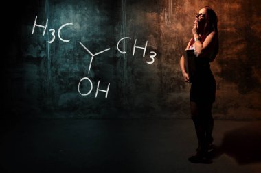 Seksi kız veya sekreter veya kız öğrenci Izopropilalkol izopropanol 2-propanol el yapımı kimyasal formül sunan