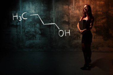 Seksi kız veya sekreter veya kız öğrenci n-butanol 1-butanol el yapımı kimyasal formül sunan