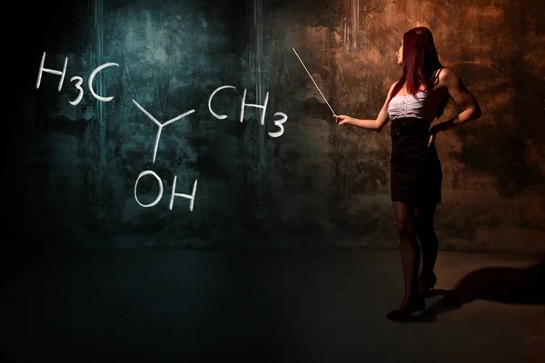 Sexy meisje of secretaresse of vrouwelijke student presenteren hand getekende chemische formule van isopropylalcohol isopropanol 2-propanol — Stockfoto