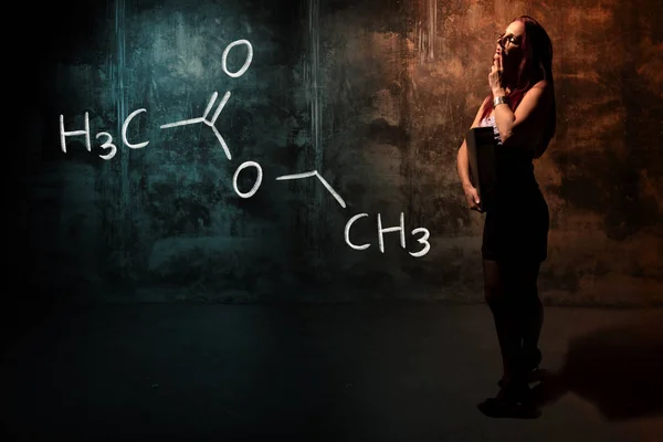 Sexy meisje of secretaresse of vrouwelijke student presenteert hand getekende chemische formule van ethylacetaat — Stockfoto