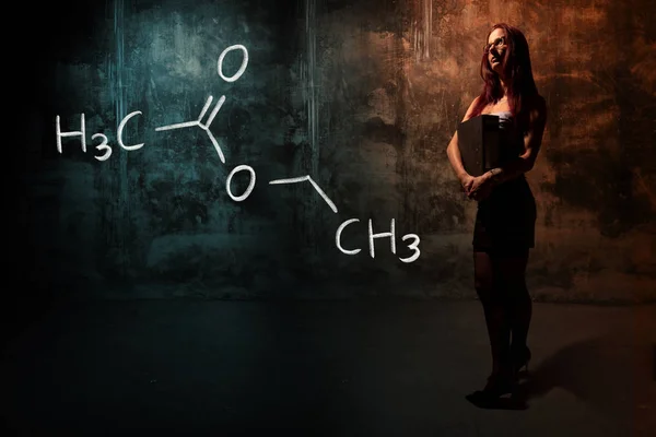 Сексуальна дівчина або секретарка або студентка, що представляє намальовану хімічну формулу етилового ацетату — стокове фото