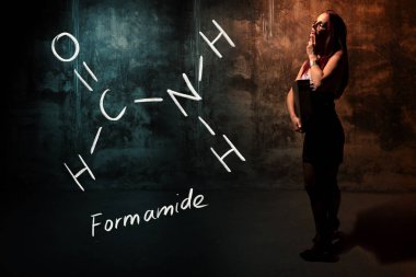 Seksi kız veya sekreter veya kadın öğrenci Formamide el yapımı kimyasal formül sunan
