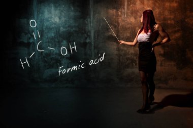 Seksi kız veya sekreter veya kadın öğrenci formik asit handdrawn kimyasal formülü sunan