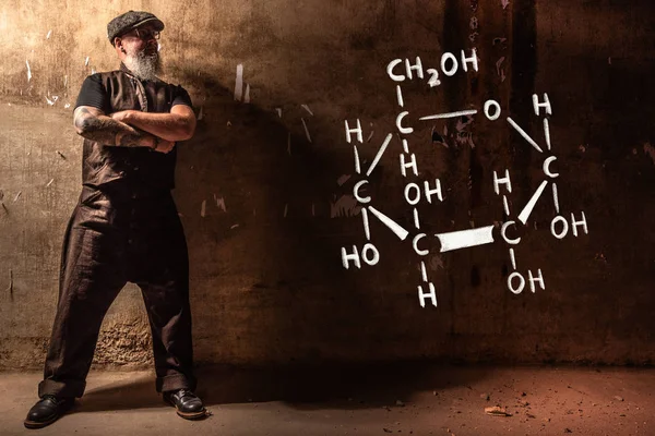 Hombre viejo barbudo que presenta fórmula química dibujada a mano de glucosa — Foto de Stock