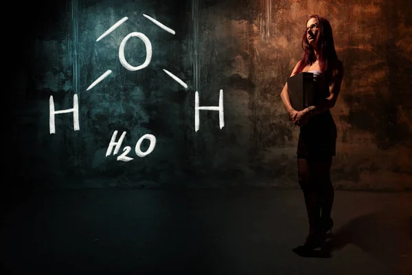 Σέξι κορίτσι ή γραμματέας ή μαθήτρια παρουσιάζοντας χημική φόρμουλα του Η2ο νερό — Φωτογραφία Αρχείου