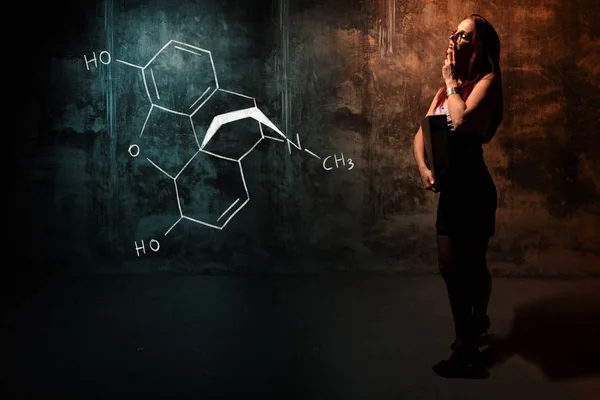 Sexy chica o secretaria o estudiante que presenta fórmula química dibujada a mano de la morfina — Foto de Stock