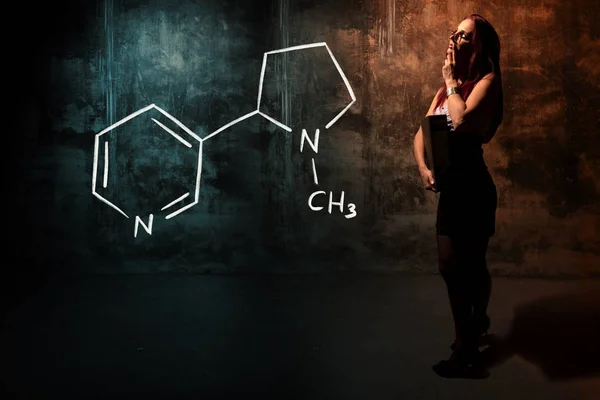 Сексуальна дівчина або секретар або жіночий студент представляючи рукамальована хімічна формула нікотину — стокове фото