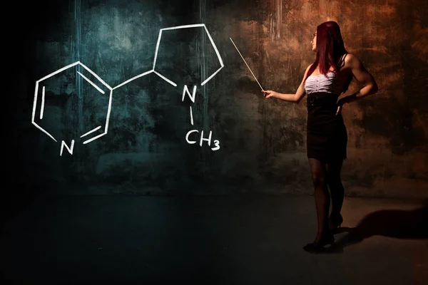 Σέξι κορίτσι ή γραμματέας ή μαθήτρια παρουσιάζοντας χημική φόρμουλα νικοτίνης — Φωτογραφία Αρχείου