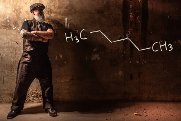 Vousatý stařík, který prezentuje ručně kreslené chemické složení hexanu — Stock fotografie