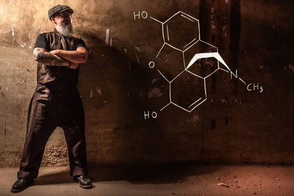 Viejo barbudo que presenta fórmula química dibujada a mano de la morfina — Foto de Stock