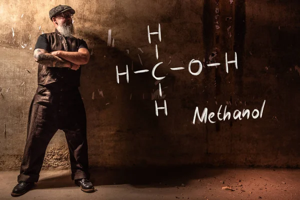 Bebaarde oude man presenteert hand getekende chemische formule van methanol — Stockfoto