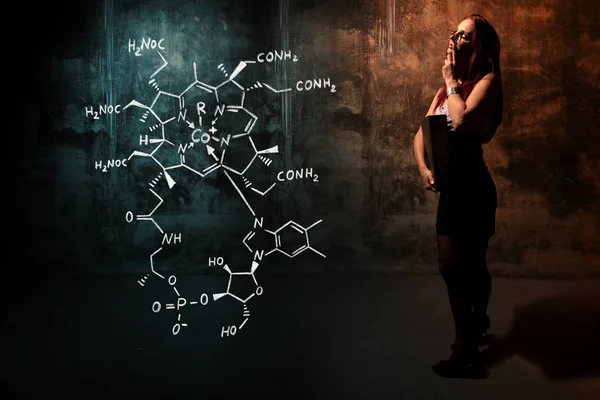Menina sexy ou secretária ou estudante do sexo feminino apresentando fórmula química desenhada à mão de vitamina B12 — Fotografia de Stock