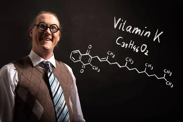 Professore che presenta la formula chimica disegnata a mano della vitamina K — Foto Stock