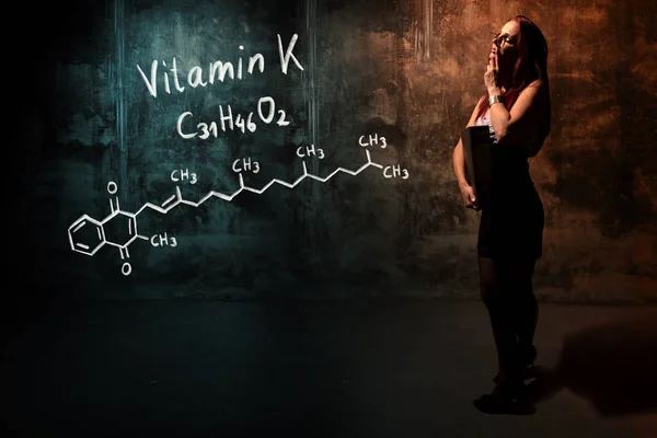 Ragazza sexy o segretaria o studentessa che presenta formula chimica disegnata a mano di vitamina K — Foto Stock