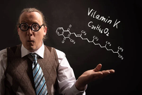 Professore che presenta la formula chimica disegnata a mano della vitamina K — Foto Stock