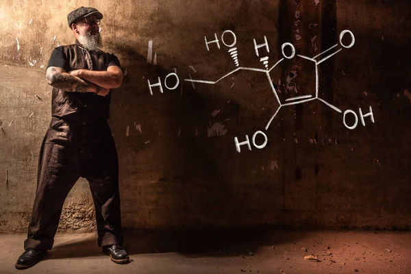 Hombre viejo barbudo que presenta fórmula química dibujada a mano de vitamina C — Foto de Stock