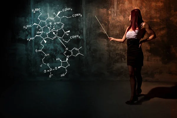 Sexy chica o secretaria o estudiante que presenta fórmula química dibujada a mano de vitamina B12 — Foto de Stock