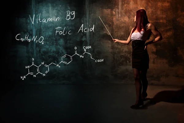 Ragazza sexy o segretaria o studentessa che presenta formula chimica disegnata a mano di vitamina B9 — Foto Stock