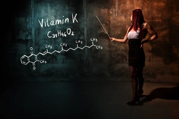 Ragazza sexy o segretaria o studentessa che presenta formula chimica disegnata a mano di vitamina K — Foto Stock