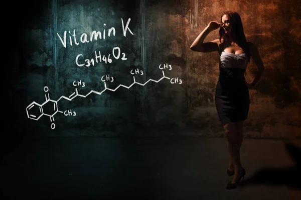 Ragazza sexy o segretaria o studentessa che presenta formula chimica disegnata a mano di vitamina K — Foto Stock