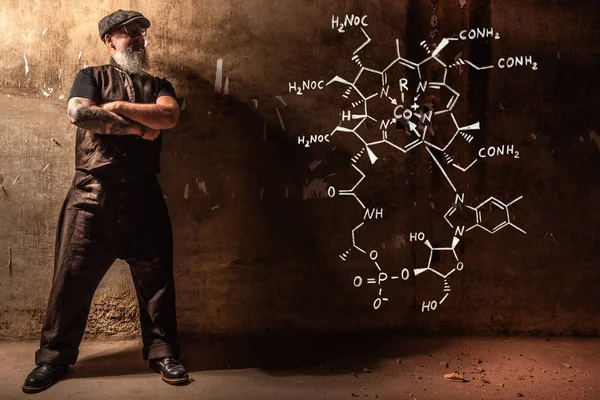 Hombre viejo barbudo que presenta fórmula química dibujada a mano de vitamina B12 — Foto de Stock