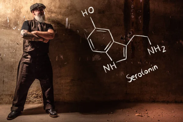 Sakallı yaşlı adam serotonin el çizilmiş kimyasal formül sunan — Stok fotoğraf